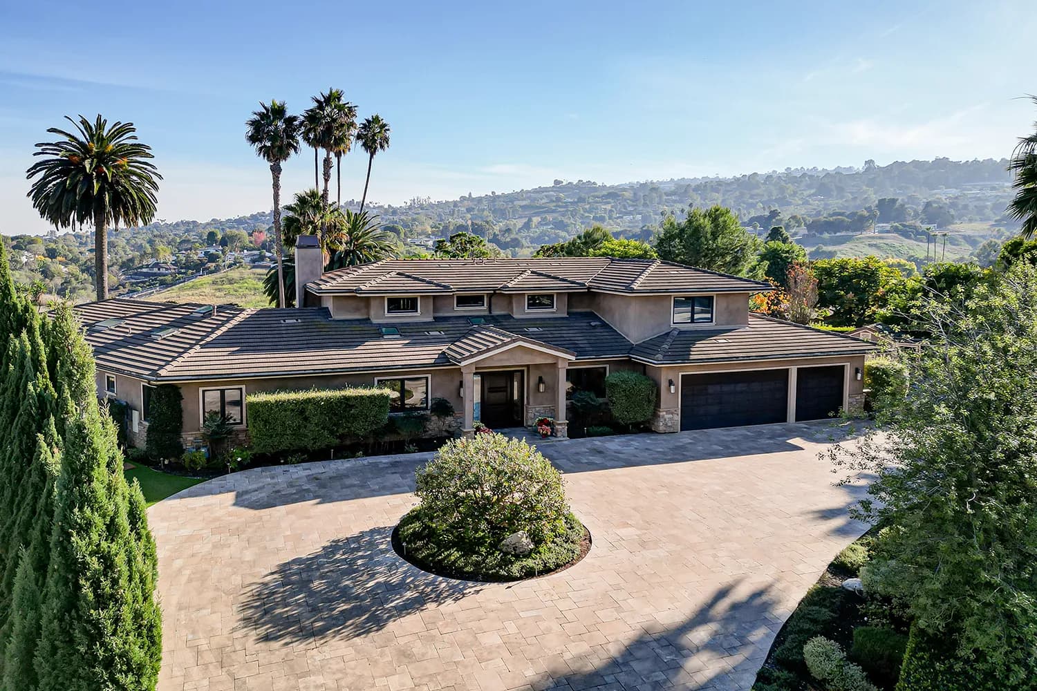 Hillside South Bay home with a circular paver driveway and canyon views